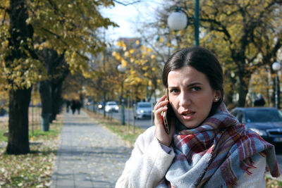 Portrait of young woman using smart phone outdoors