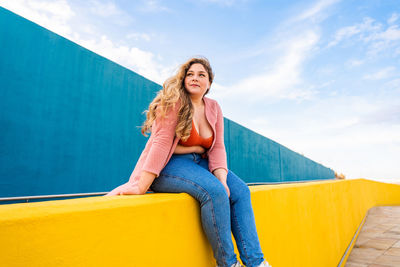 Low angle view of woman standing against sky