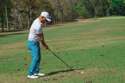 Full length of man playing golf in course