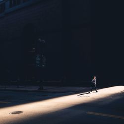 Woman walking on road at night