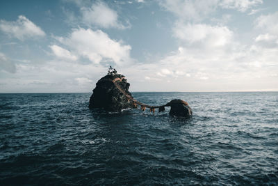 Scenic view of rock formation in sea against sky