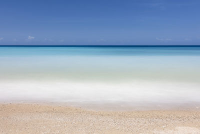 Scenic view of beach against blue sky