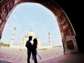 Rear view of couple standing against sky