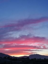 Scenic view of silhouette mountains against dramatic sky