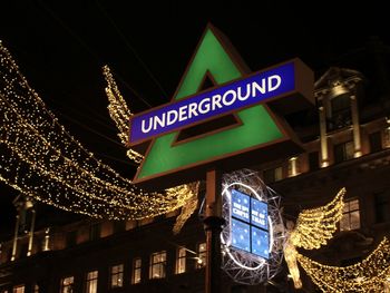 Low angle view of illuminated text on building at night