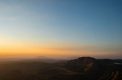 Scenic view of mountains against clear sky during sunset