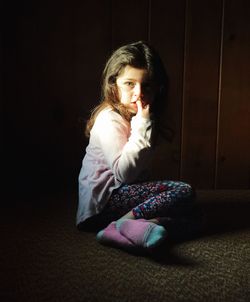 Full length of girl sitting at home