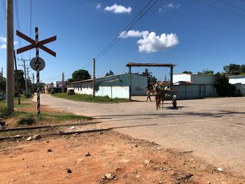 People on railroad track against sky