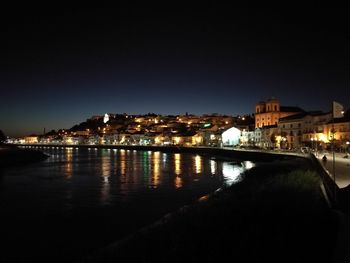 Illuminated buildings against sky at night