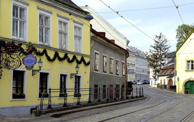 Buildings by street in city against sky