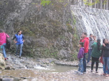 Full length of friends against waterfall