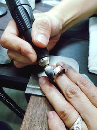 High angle view of woman polishing ring jewelry