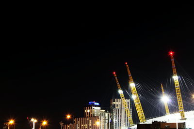 Low angle view of illuminated city against sky at night