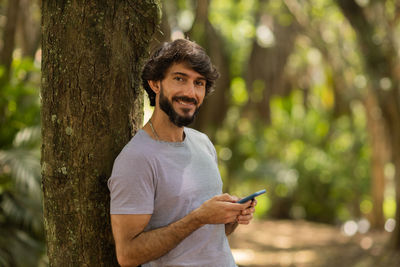 Young man at park on a beautiful sunny day with mobile phone.  working  leisure. green and nature 