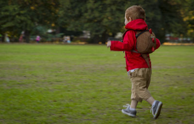 Full length of boy walking on grassy field