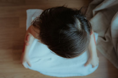 Rear view of man sleeping on bed at home