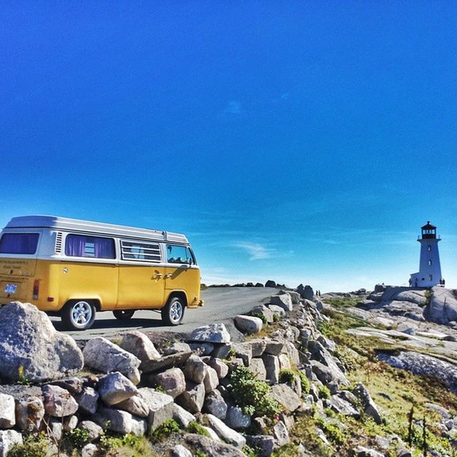 blue, transportation, clear sky, building exterior, mode of transport, copy space, built structure, architecture, yellow, rock - object, land vehicle, sky, car, no people, outdoors, guidance, day, sunlight, travel, history