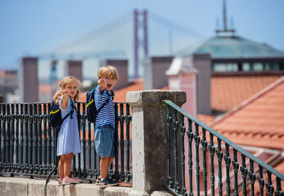 Full length of couple standing against railing