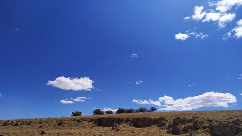 Low angle view of land against blue sky