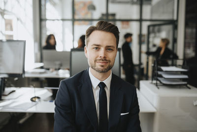 Portrait of male entrepreneur wearing black blazer at office