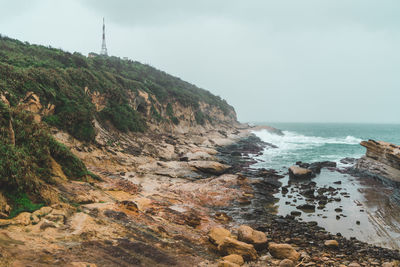 Scenic view of rocks on beach against sky