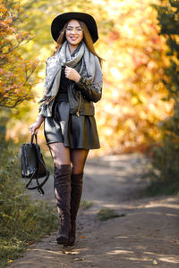 Portrait of young woman standing on field