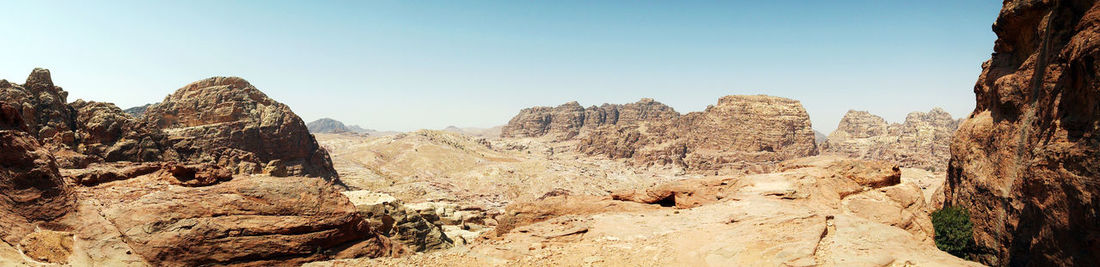 Panoramic view of rocky mountains against clear sky