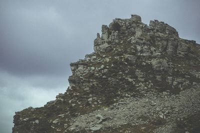 Low angle view of rocky mountain against sky