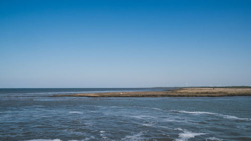 Scenic view of sea against clear blue sky