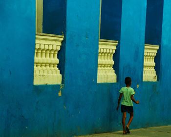 Boy walking by wall