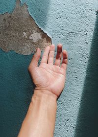 Close-up of hand touching wall