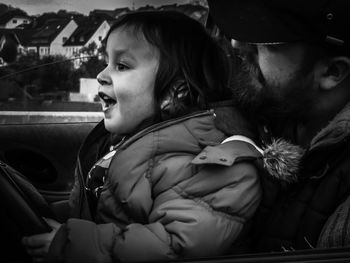 Side view of siblings sitting in car