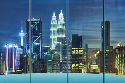 Illuminated modern buildings against sky at night