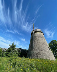 Traditional windmill on field against sky