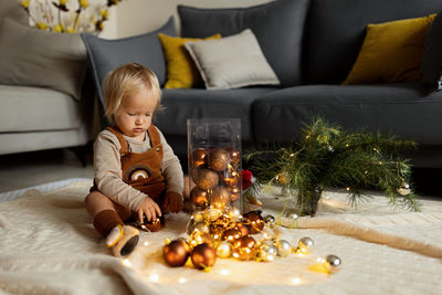 High angle view of cute girl sitting by christmas decoration