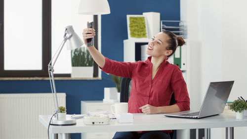 Businesswoman taking selfie at office