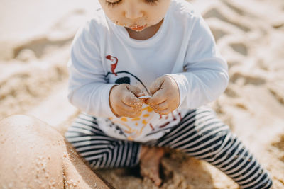 High angle view of boy holding sand