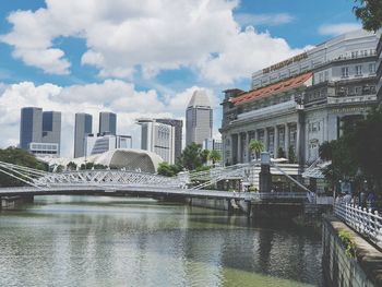 Bridge over river in city against sky