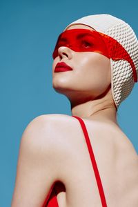 Low angle view of young woman against blue background