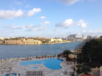 Panoramic view of city by sea against sky