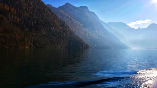 Scenic view of lake by mountains against sky