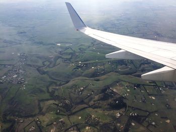 Cropped image of airplane wing over landscape