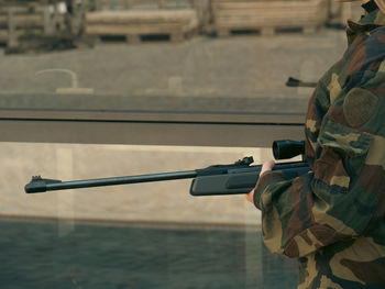 Caucasian blond teen aged soldier girl on a checkpoint holding a rifle