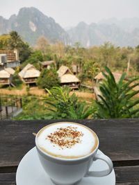 Coffee on table against mountains