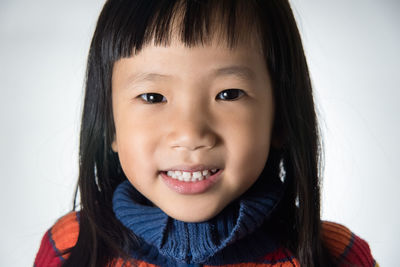 Portrait of smiling girl against white background