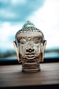 Close-up of buddha statue on table