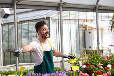 Young man smiling while holding flowering plant