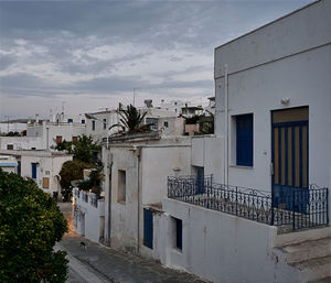 Houses by street in town against sky