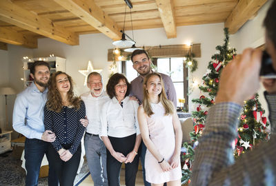 Family posing for a photo at christmas tree