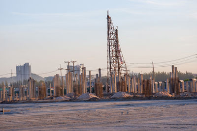 Cranes in city against sky during winter